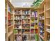 Spacious walk-in pantry with wooden shelving, offering ample storage for food and household items at 6875 Myakka Valley Trl, Sarasota, FL 34241