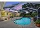 A covered pool with a hot tub is surrounded by potted plants and offers a tranquil outdoor retreat at 6875 Myakka Valley Trl, Sarasota, FL 34241
