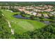 Aerial view of a community of homes on a golf course with a pond at 7343 Birds Eye Ter, Bradenton, FL 34203