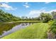Water view from a lush green backyard with beautiful landscaping on a sunny day at 7343 Birds Eye Ter, Bradenton, FL 34203