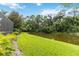 Green backyard featuring a pond and landscaping with a screened in patio at 7343 Birds Eye Ter, Bradenton, FL 34203