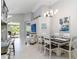 Stylish dining area with modern chandelier, open layout, view to outdoor pool, and comfortable seating at 7343 Birds Eye Ter, Bradenton, FL 34203
