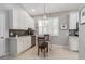 Well-lit eat-in kitchen boasts white cabinetry, stainless appliances, and a stylish chandelier above the dining area at 7343 Birds Eye Ter, Bradenton, FL 34203