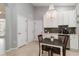 Kitchen dining area features white cabinetry, stainless appliances, tile floors and stylish chandelier at 7343 Birds Eye Ter, Bradenton, FL 34203