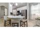 Charming kitchen features a quartz countertop island with bar stool seating, stainless appliances, and neutral design elements at 7343 Birds Eye Ter, Bradenton, FL 34203