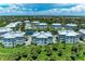 Aerial view of condo complex with a serene pond, surrounded by lush greenery and multiple residential buildings at 7820 34Th W Ave # 102, Bradenton, FL 34209