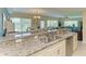 Open layout showcasing a granite countertop, stainless steel dishwasher, and open view to dining and living area at 7820 34Th W Ave # 102, Bradenton, FL 34209
