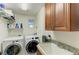 Modern laundry room with washer, dryer, storage cabinet and granite countertop with utility sink at 7820 34Th W Ave # 102, Bradenton, FL 34209