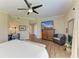 Bright main bedroom featuring a ceiling fan, desk, television, chair and ensuite bathroom entrance at 7820 34Th W Ave # 102, Bradenton, FL 34209