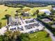 A lovely aerial view of the community clubhouse and golf course with a parking lot and tennis court nearby at 8312 Misty Lake Cir, Sarasota, FL 34241