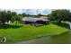 A tranquil backyard featuring a screened pool, lake views, and a well-maintained lawn at 8312 Misty Lake Cir, Sarasota, FL 34241