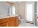 Bathroom featuring a white vanity with a sink and cherry wood cabinets plus a walk-in shower and access to the outdoors at 8312 Misty Lake Cir, Sarasota, FL 34241