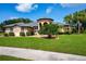 Beautiful single-story home boasting lush front lawn, mature landscaping, and charming, covered entryway at 8312 Misty Lake Cir, Sarasota, FL 34241
