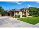Lovely one story home with a wide driveway, 2-car garage, trimmed shrubbery, and covered front porch entrance at 8312 Misty Lake Cir, Sarasota, FL 34241