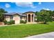 Charming one-story home with manicured lawn and covered entrance, complemented by lush landscaping and mature trees at 8312 Misty Lake Cir, Sarasota, FL 34241