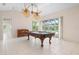 Spacious game room with a billiard table, tropical ceiling fans, and bright light from views of the lanai and pool at 8312 Misty Lake Cir, Sarasota, FL 34241