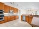 Bright kitchen featuring light oak cabinets, stainless appliances, and tile flooring; open to living area at 8312 Misty Lake Cir, Sarasota, FL 34241