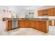 Open-concept kitchen with wooden cabinets, an island, and stainless steel appliances; bright and airy at 8312 Misty Lake Cir, Sarasota, FL 34241