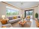 Cozy living room with large windows, comfortable sofa, and a view of lush greenery at 8312 Misty Lake Cir, Sarasota, FL 34241