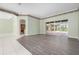 Open-concept living room with sliding glass doors to the pool area and wood-look flooring at 8312 Misty Lake Cir, Sarasota, FL 34241