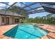 Screened in pool and jacuzzi overlook a scenic lake at 8312 Misty Lake Cir, Sarasota, FL 34241
