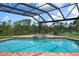 Stunning pool area with a built-in spa, a covered enclosure, and picturesque water views at 8312 Misty Lake Cir, Sarasota, FL 34241