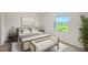 Cozy bedroom with a neutral palette, a large window offering natural light, and simple elegant furniture at 8557 Milestone Dr, Sarasota, FL 34238