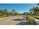 Gated entrance to the community with lush landscaping and palm trees at 8557 Milestone Dr, Sarasota, FL 34238