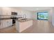 Modern kitchen with stainless steel appliances, an island, and sliding doors to the outside at 8557 Milestone Dr, Sarasota, FL 34238