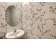 Stylish powder room featuring a round mirror and unique wallpaper at 8557 Milestone Dr, Sarasota, FL 34238