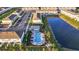 Aerial view of community pool, pond, parking and residential buildings on a sunny day at 8709 Daybreak St, Sarasota, FL 34241
