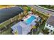 Aerial view of the community pool, surrounded by seating, landscaping, and a nearby pond at 8709 Daybreak St, Sarasota, FL 34241