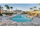 Community pool area with lounge chairs, picnic tables, and a small building in the background at 8709 Daybreak St, Sarasota, FL 34241