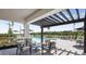 Outdoor pool area with covered pergola, modern seating and lounge chairs and well-maintained landscaping at 8709 Daybreak St, Sarasota, FL 34241