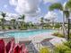 Community pool surrounded by lounge chairs, umbrellas, tropical plants, and landscaping at 8733 Winter Breeze Way, Sarasota, FL 34241