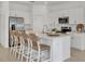 Modern white kitchen with stainless steel appliances, large island, bar seating, and ample counter space at 8733 Winter Breeze Way, Sarasota, FL 34241