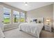 Bright bedroom with three windows, a plush queen-size bed, and a view of the green outdoor landscape at 9040 Tequila Sunrise Dr, Sarasota, FL 34241