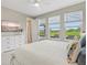 Comfortable bedroom with a queen-size bed, three windows, light gray walls, and a white ceiling fan at 9040 Tequila Sunrise Dr, Sarasota, FL 34241