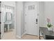 Elegant entryway featuring a modern door, stylish console table, and a glimpse into a powder room at 9040 Tequila Sunrise Dr, Sarasota, FL 34241