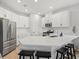 Bright kitchen with white cabinets, a large island with seating, and stainless steel appliances at 9040 Tequila Sunrise Dr, Sarasota, FL 34241