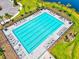 Aerial view of community lap pool, surrounded by lounge chairs, with lush landscaping and nearby parking at 9040 Tequila Sunrise Dr, Sarasota, FL 34241