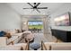 Sunlit living room features a large sectional, light wood floors, and seamless access to the outdoor patio at 9040 Tequila Sunrise Dr, Sarasota, FL 34241