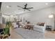 Open concept living room featuring a large sectional, ceiling fan, and seamless transition to the kitchen at 9040 Tequila Sunrise Dr, Sarasota, FL 34241