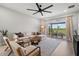 Bright living room with large sectional couch, ceiling fan, and sliding glass doors to a covered patio at 9040 Tequila Sunrise Dr, Sarasota, FL 34241