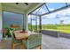 This charming patio with a wood dining table looks out to the spacious manicured backyard at 9040 Tequila Sunrise Dr, Sarasota, FL 34241