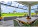 Relaxing screened-in patio features a dining table with tranquil views of the green lawn at 9040 Tequila Sunrise Dr, Sarasota, FL 34241