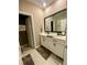 Modern bathroom with double vanity, white cabinets, large mirror, and tile flooring at 11613 Woodleaf Dr, Lakewood Ranch, FL 34211