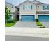 Inviting townhome exterior featuring a blue garage door, neutral siding, and a paved driveway at 11613 Woodleaf Dr, Lakewood Ranch, FL 34211