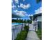 Community pool area with a fence, lounge chairs, and surrounding tropical landscape at 11613 Woodleaf Dr, Lakewood Ranch, FL 34211