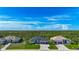Expansive aerial shot showcasing three homes with meticulously maintained lawns and picturesque natural surroundings at 1167 Boundary Blvd, Rotonda West, FL 33947